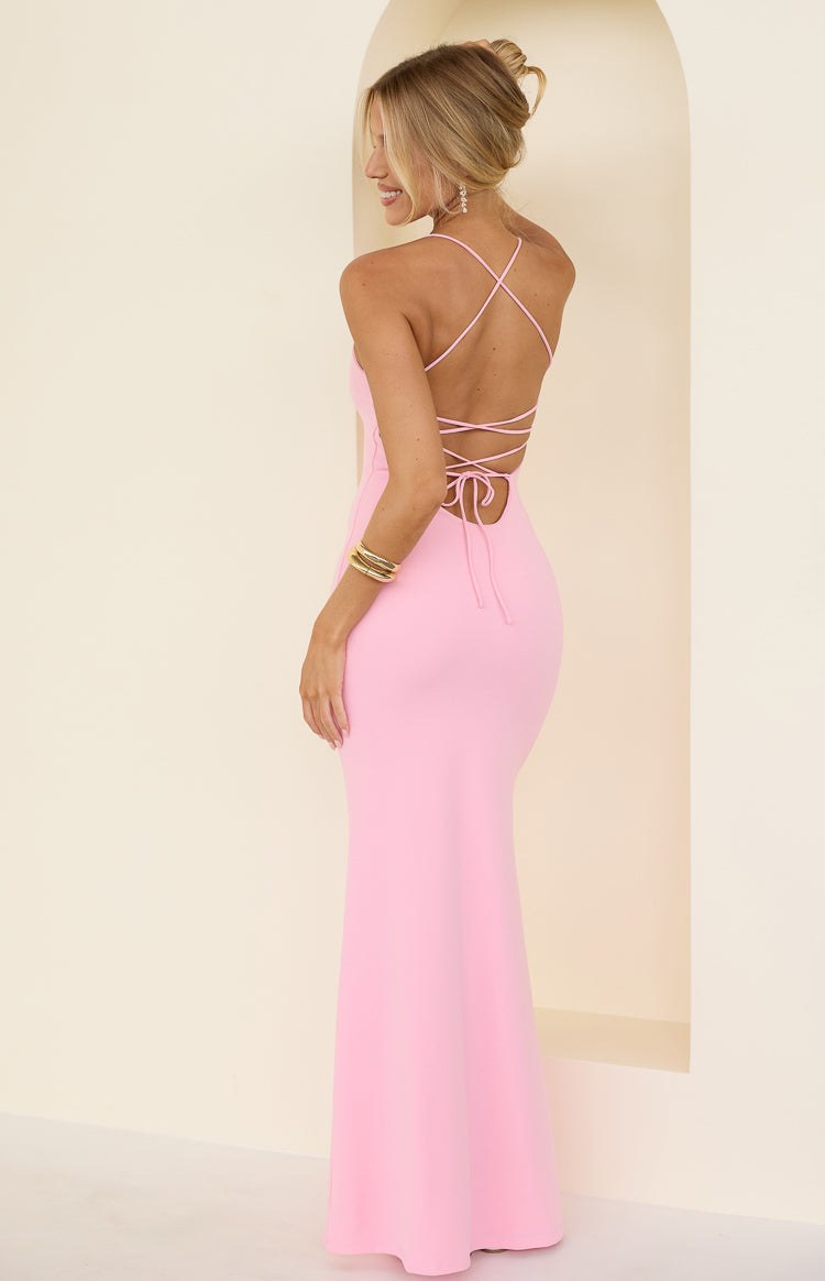 Model showing the intricate strappy open back design of a light pink floor length crepe dress perfect for a summer prom
